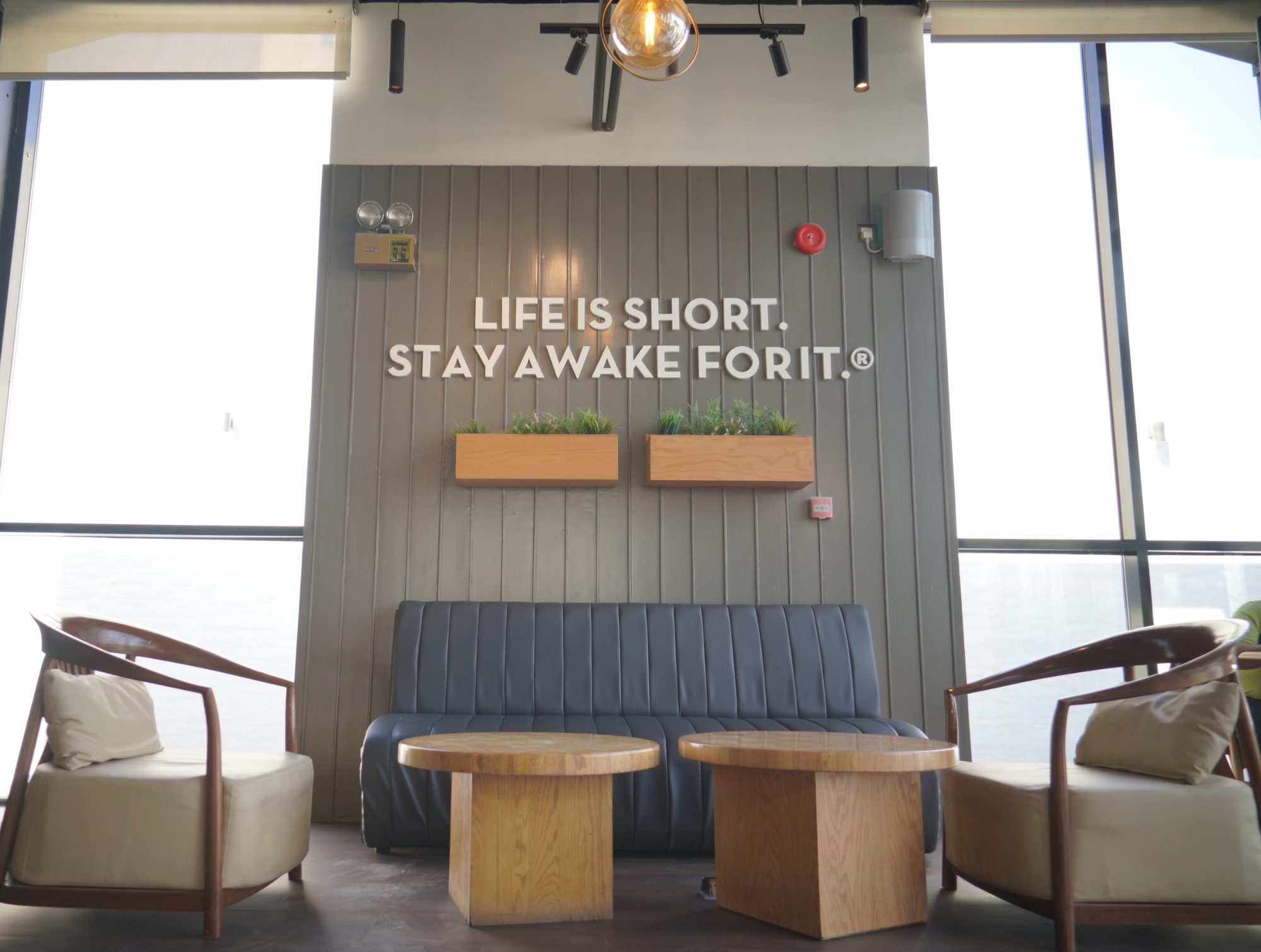 Seating under the Life is short. Stay awake for it. wall in a Caribou Coffee branch